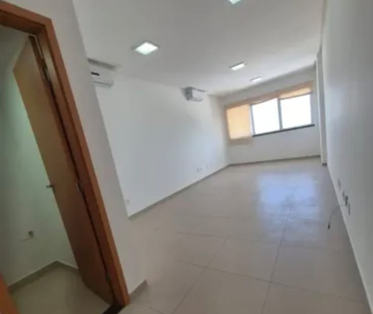 A sala vazia, em toda a sua extensão.